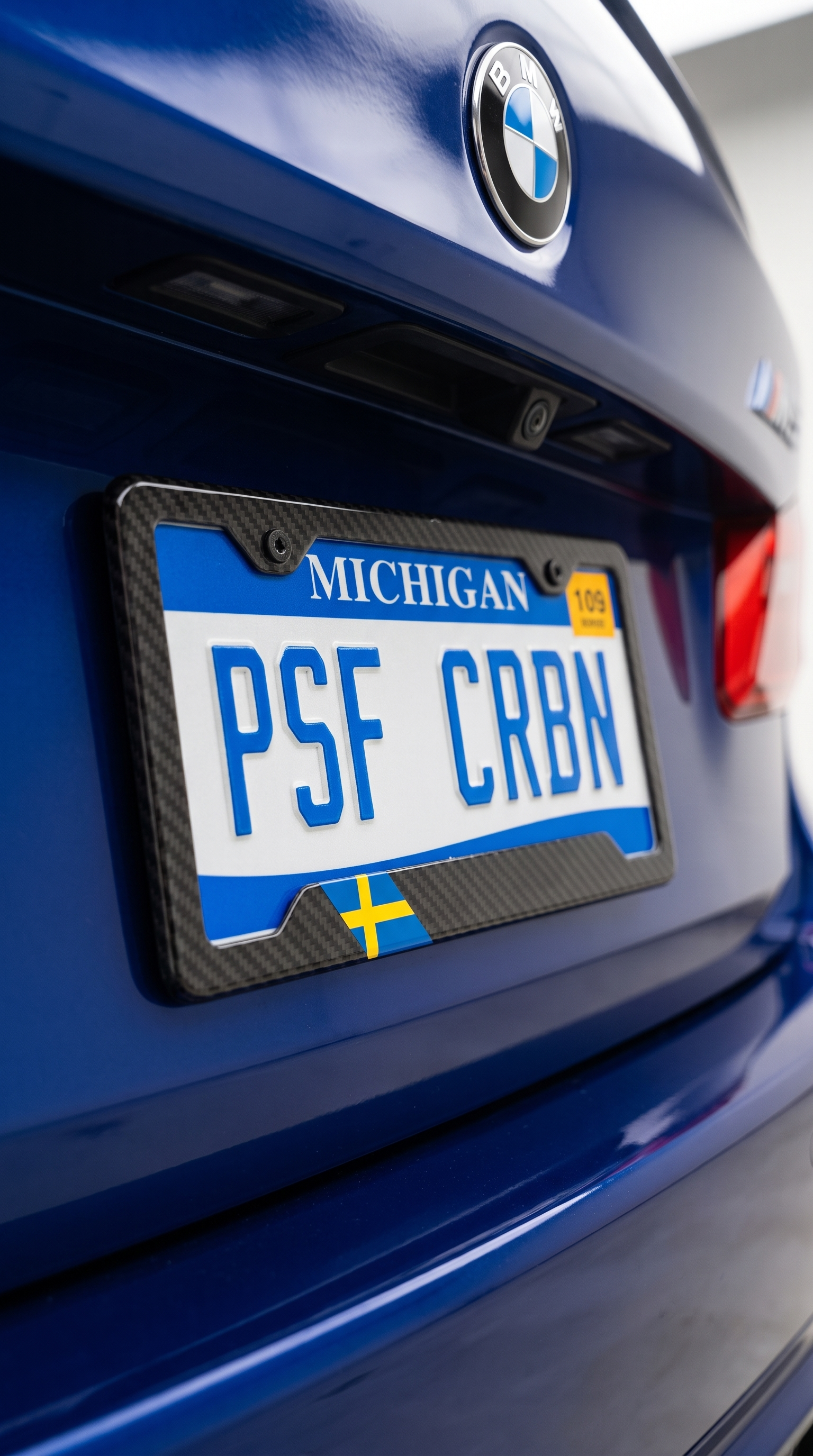 Sweden flag carbon fiber license plate frame close-up on blue BMW M5