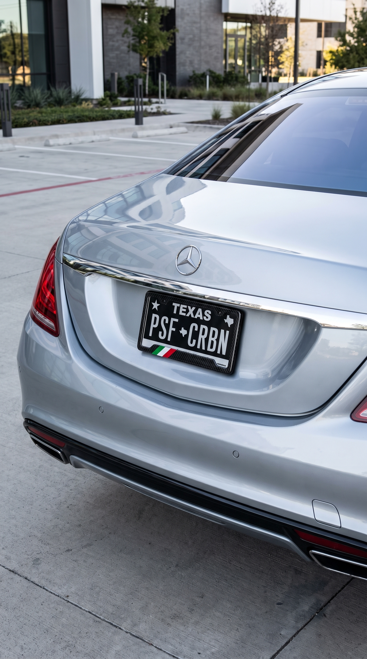 Italy flag carbon fiber license plate frame on rear of silver Mercedes S-Class, wide shot