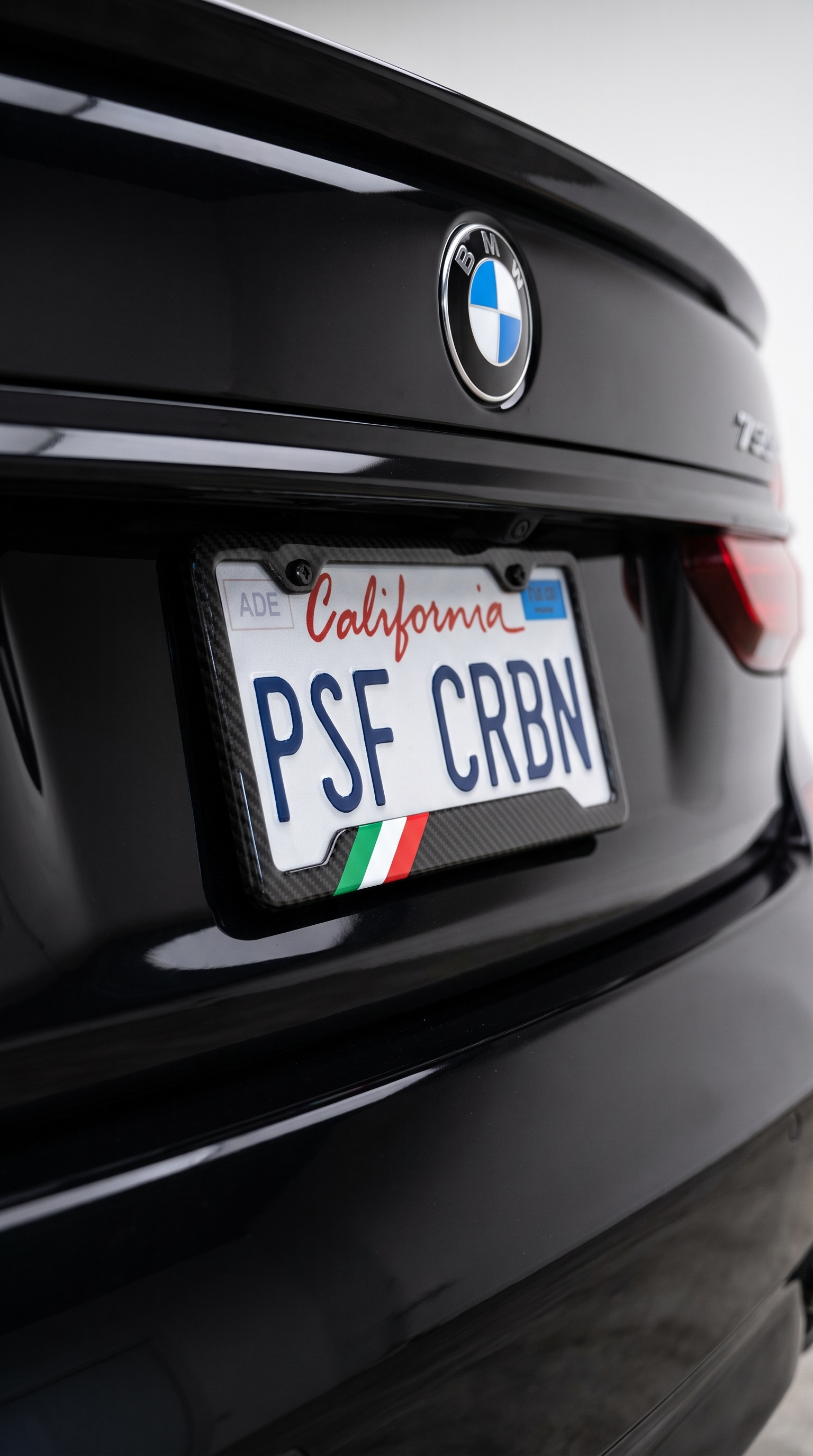Italy flag carbon fiber license plate frame close-up on black BMW 7 Series