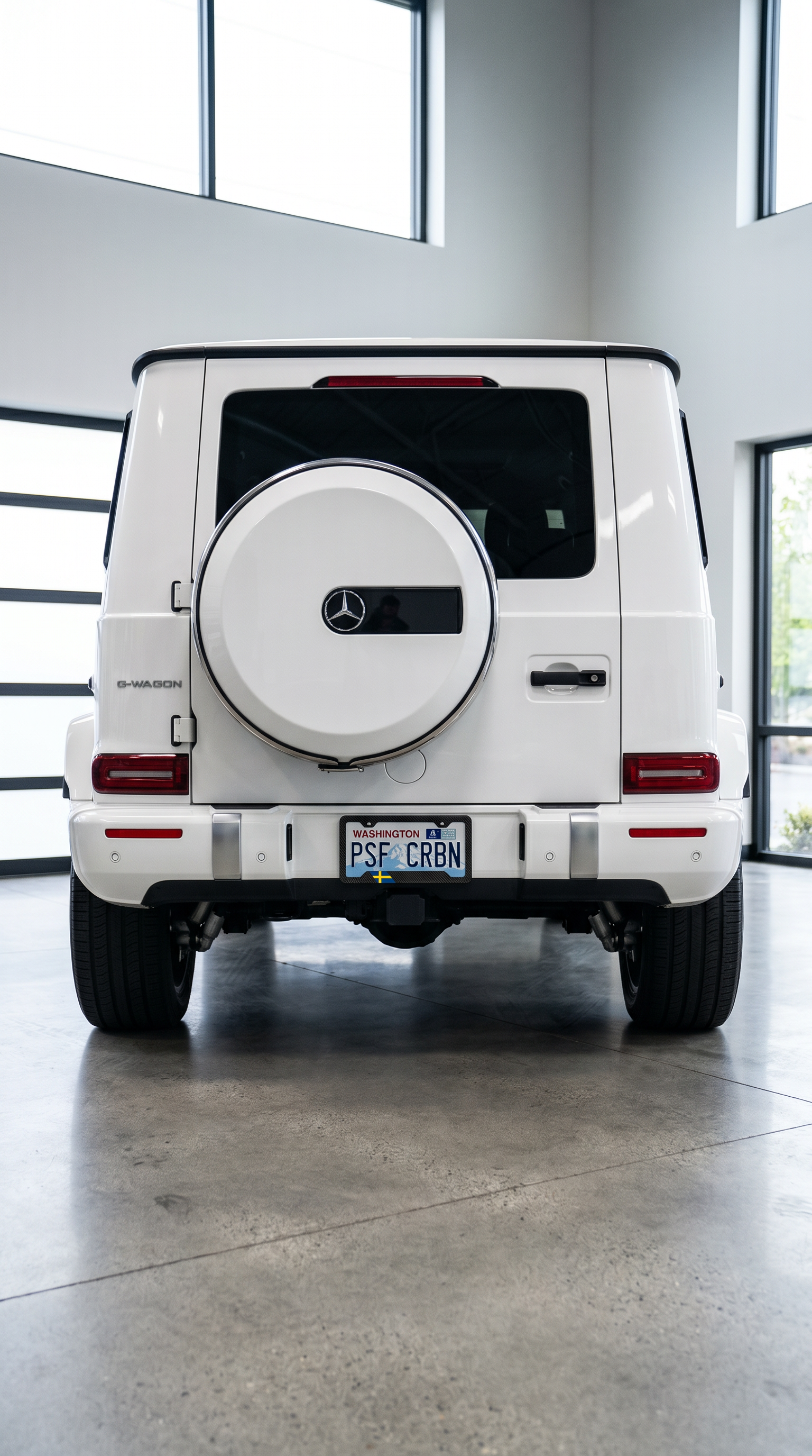Sweden flag carbon fiber license plate frame on rear of white Mercedes G-Wagon, wide shot