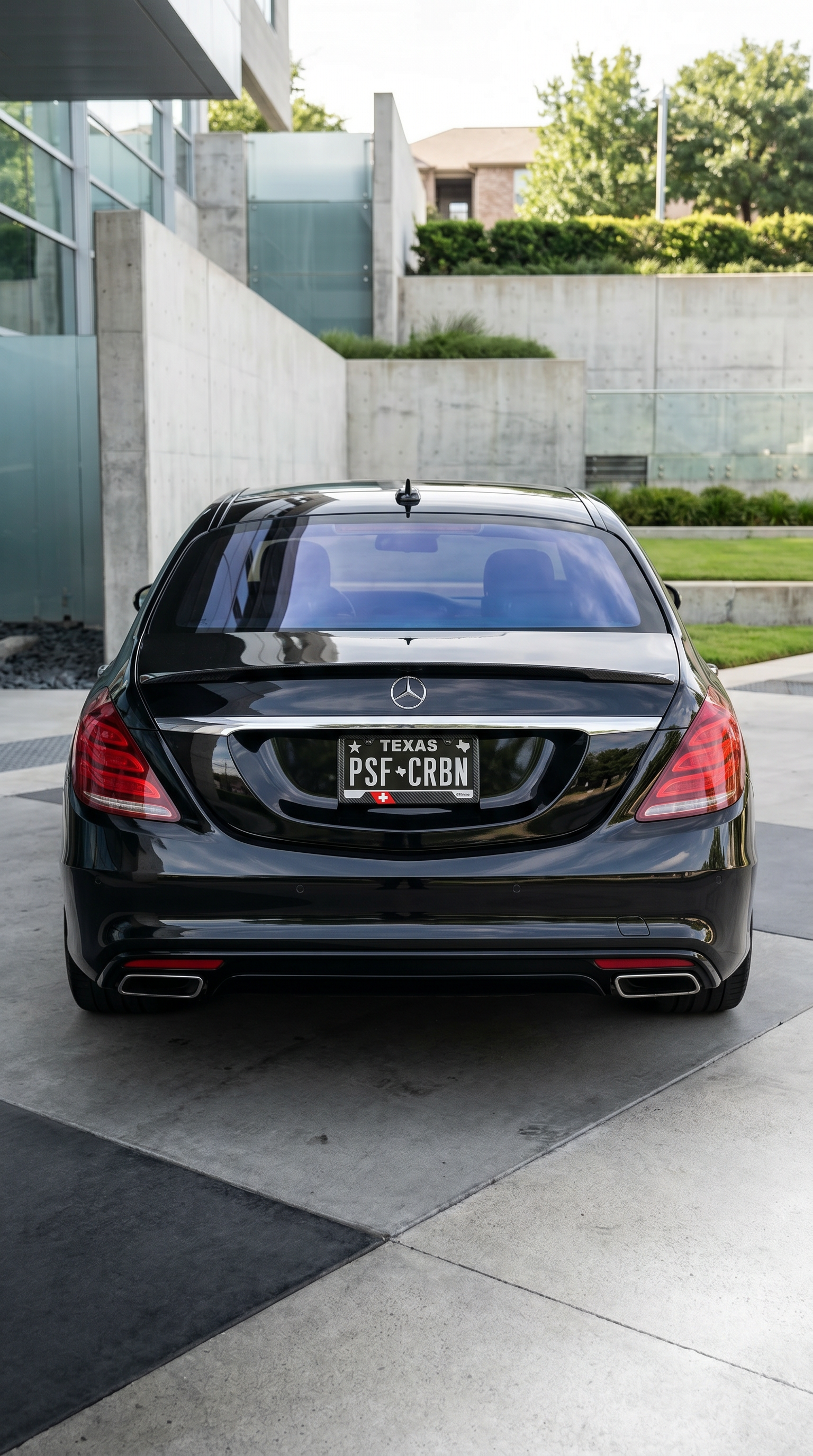 Switzerland flag carbon fiber license plate frame on rear of black Mercedes S-Class, wide shot