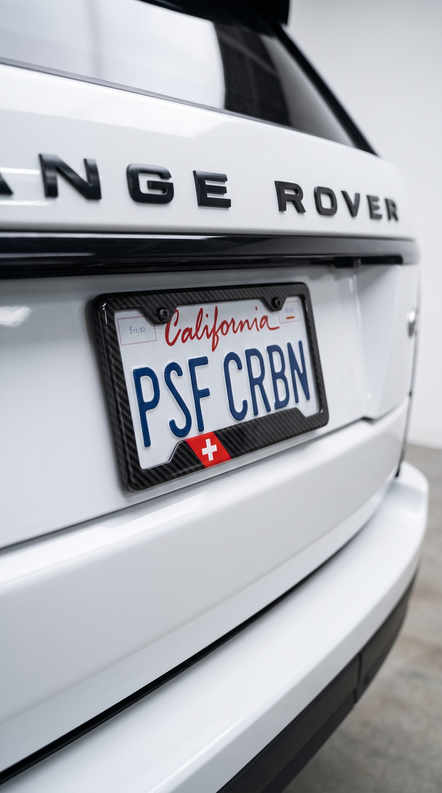 Switzerland flag carbon fiber license plate frame close-up on white Range Rover