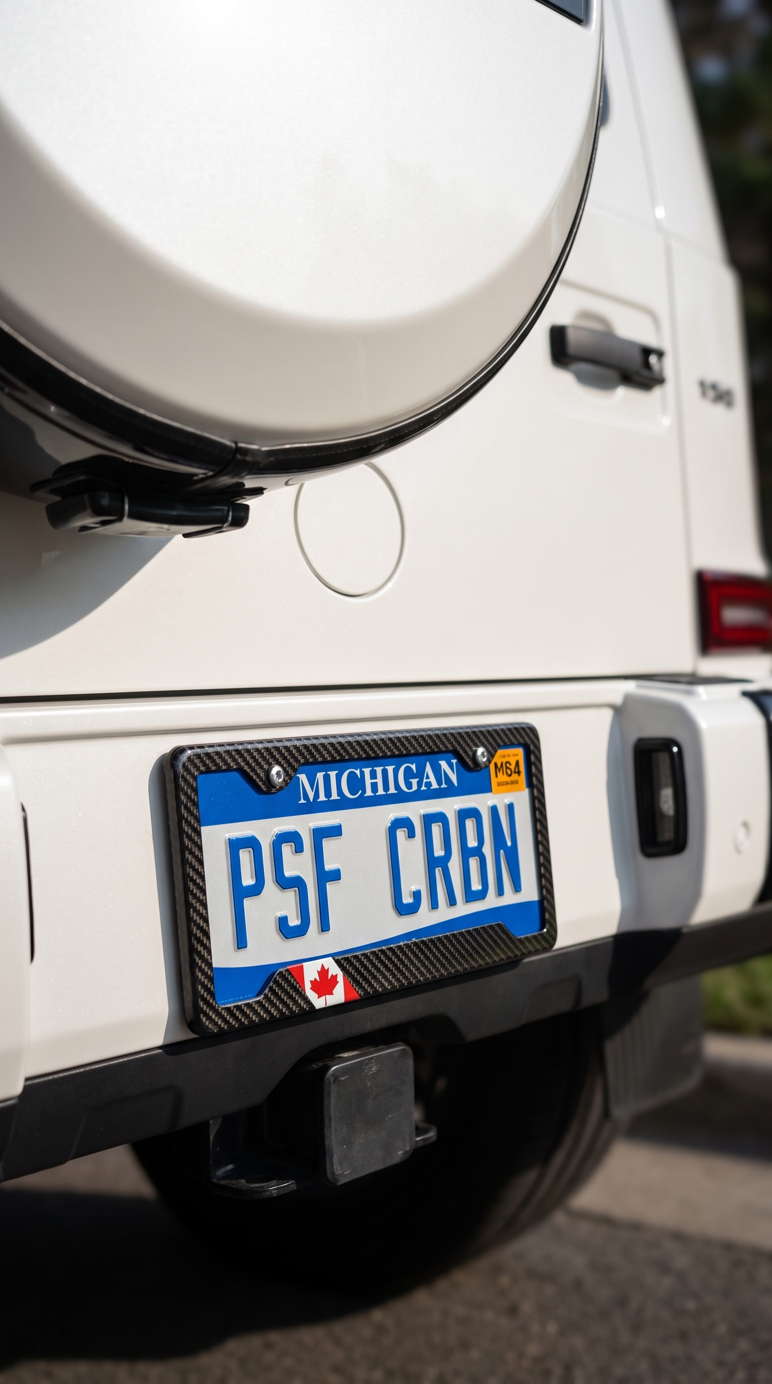 Canada flag carbon fiber license plate frame close-up on pearl white Mercedes G-Wagon