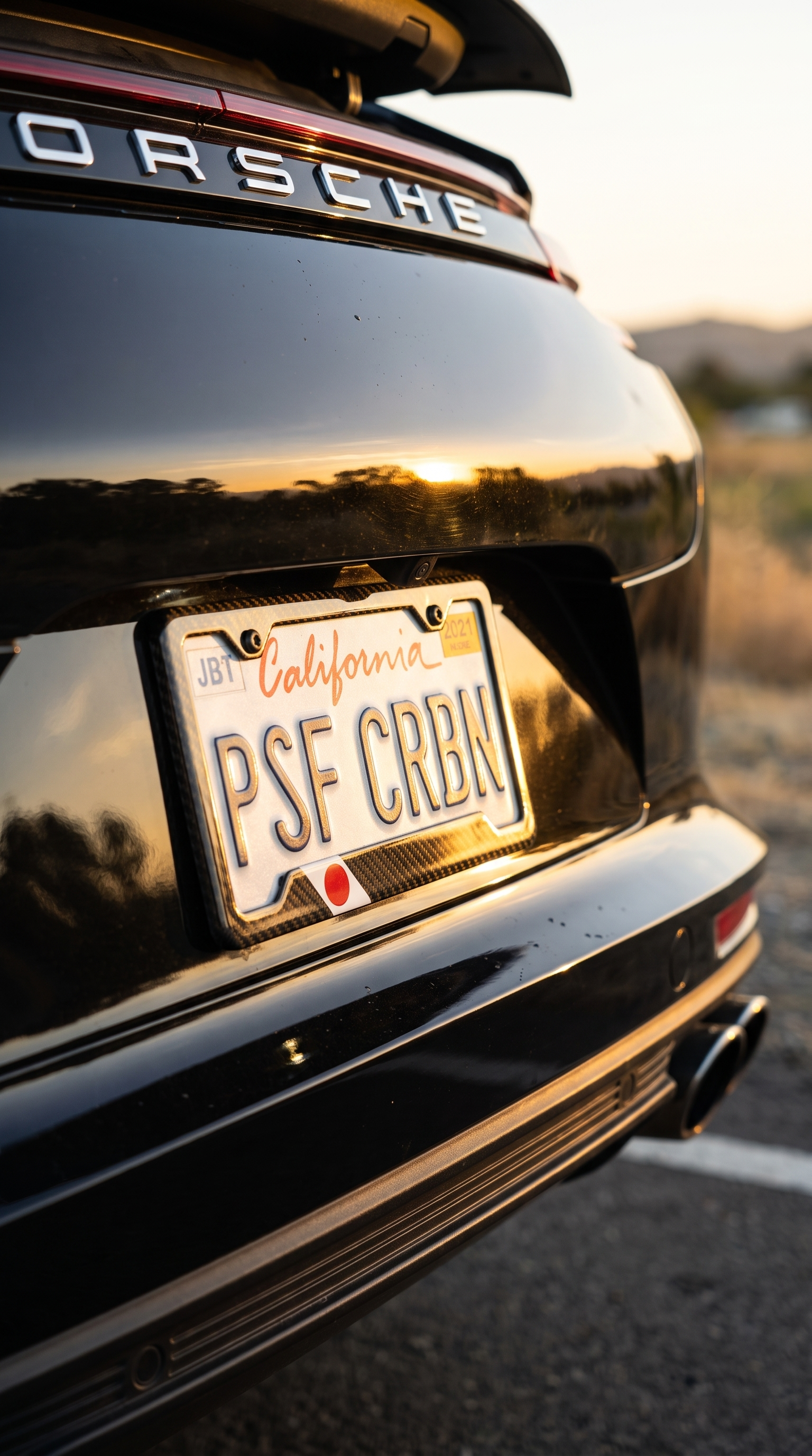 Japan flag carbon fiber license plate frame on Porsche Panamera, three-quarter angle, California plate PSF CRBN
