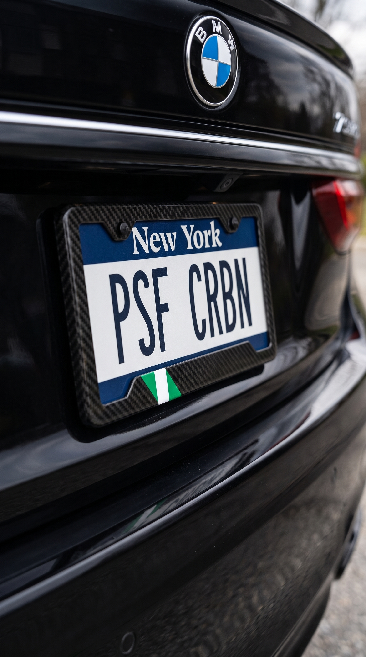 Nigeria flag carbon fiber plate frame close-up on black BMW 7 Series, New York plate PSF CRBN