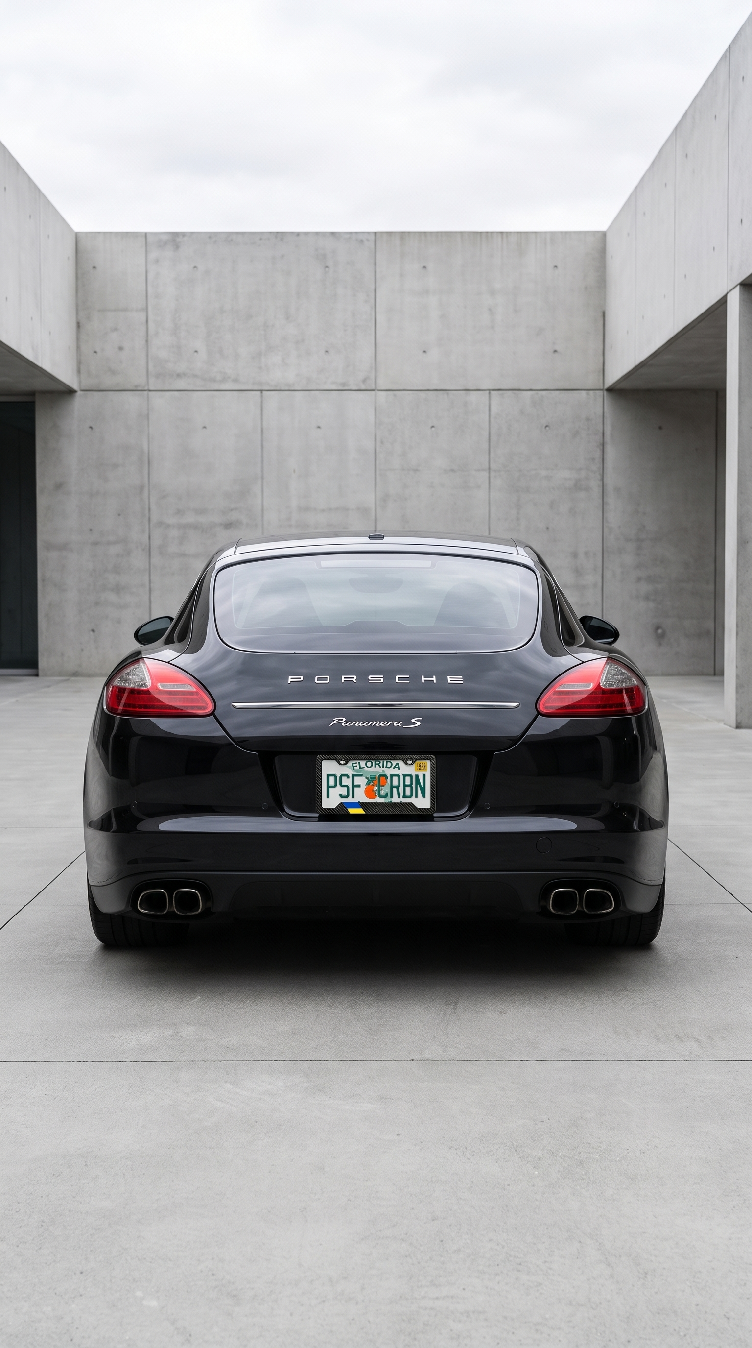 Ukraine flag carbon fiber license plate frame on rear of black Porsche Panamera, wide shot