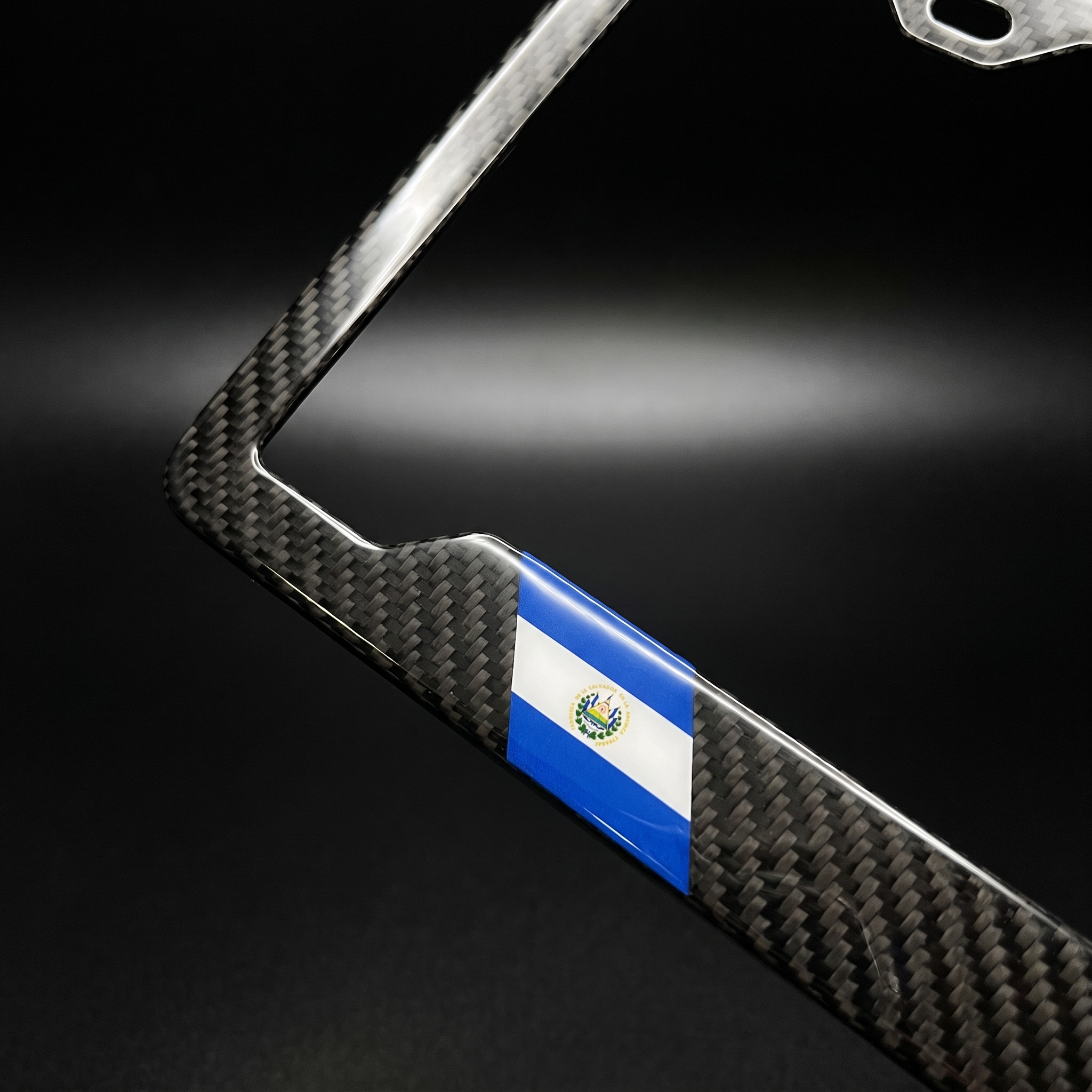 El Salvador flag carbon fiber license plate frame — angled corner macro