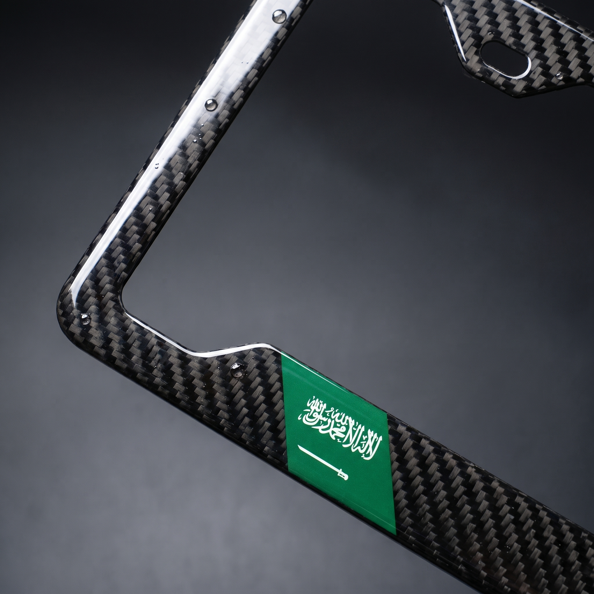 Saudi Arabia flag carbon fiber license plate frame — angled corner macro