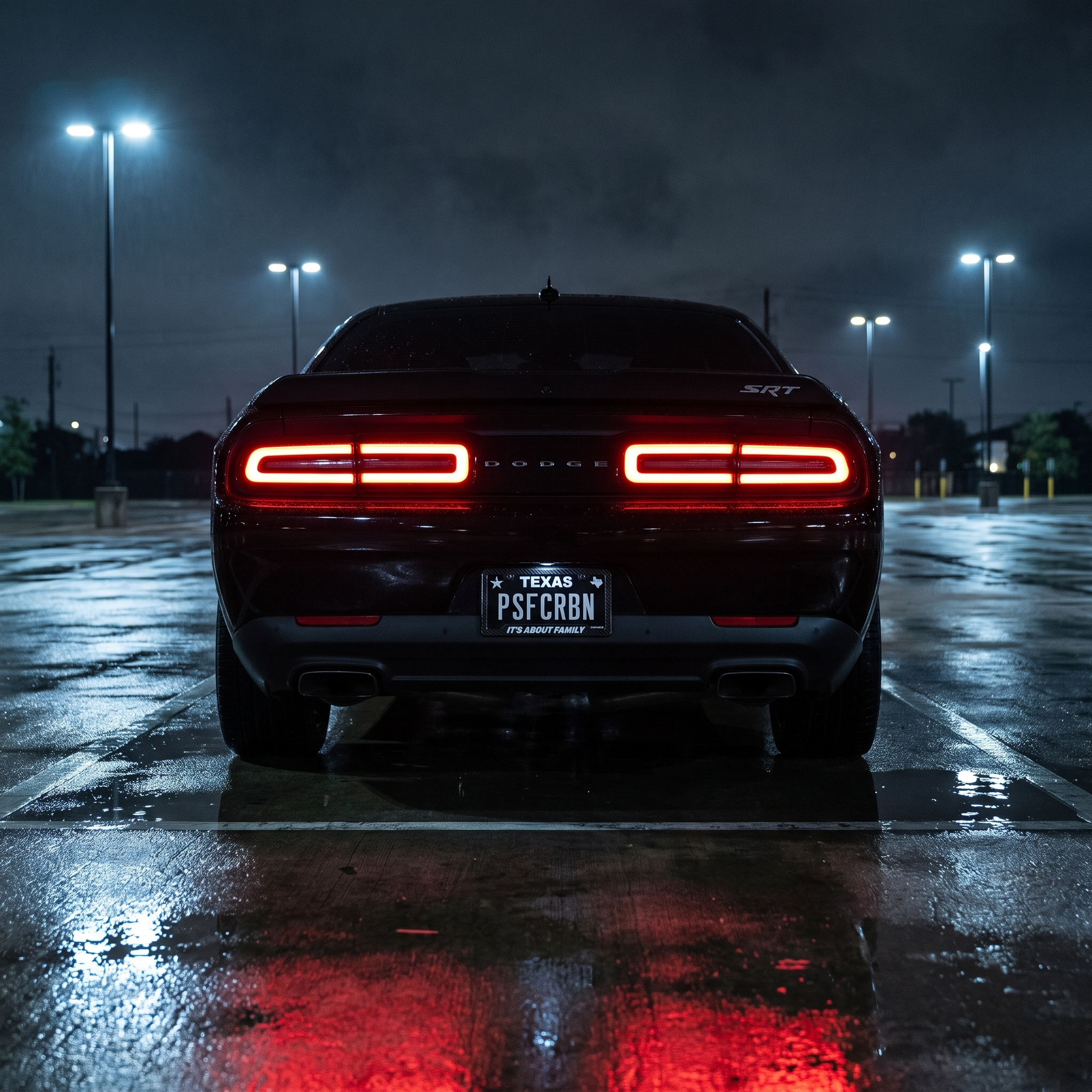 It's About Family frame on a black Dodge Challenger SRT in a wet night parking lot